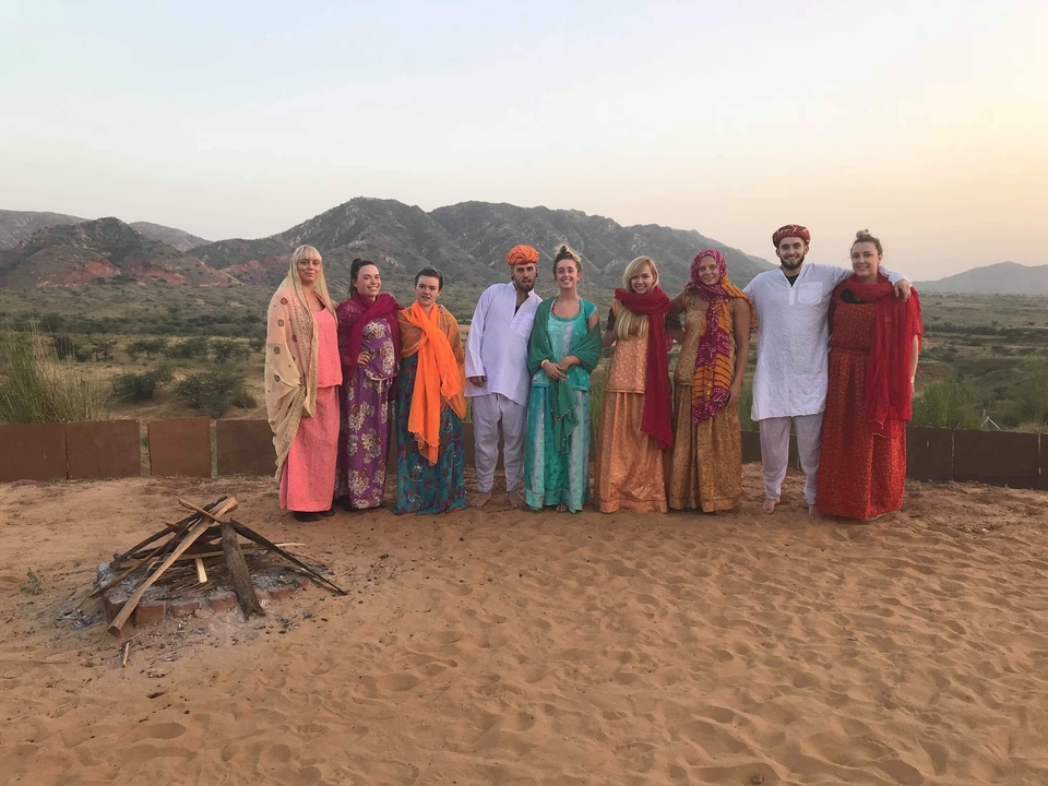 Groupe de personnes en tenue traditionnelle posant en plein air.