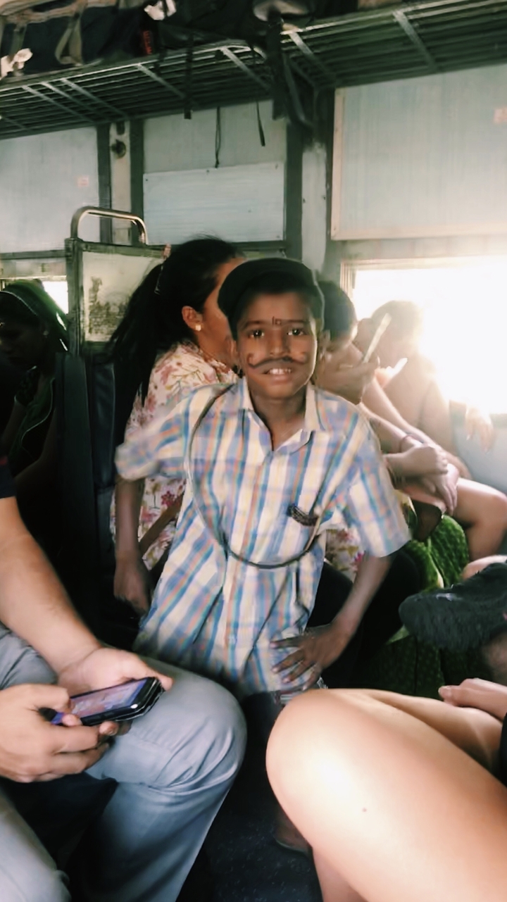 Garçon avec une moustache dessinée dans un train bondé.