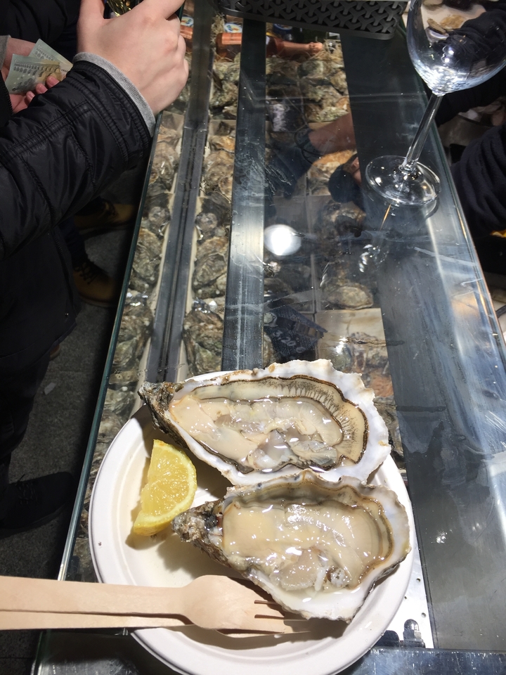 Gros plan d'une huître avec sa coquille sur un plateau.