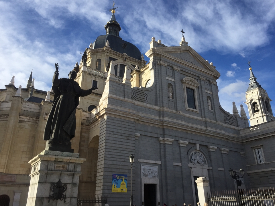 Façade de cathédrale avec une statue au premier plan.
