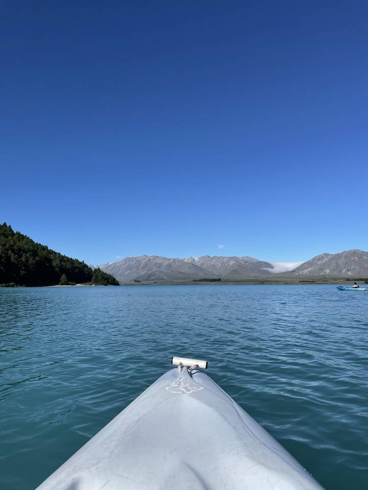 Bow of a boat on a lake with mountainous background.