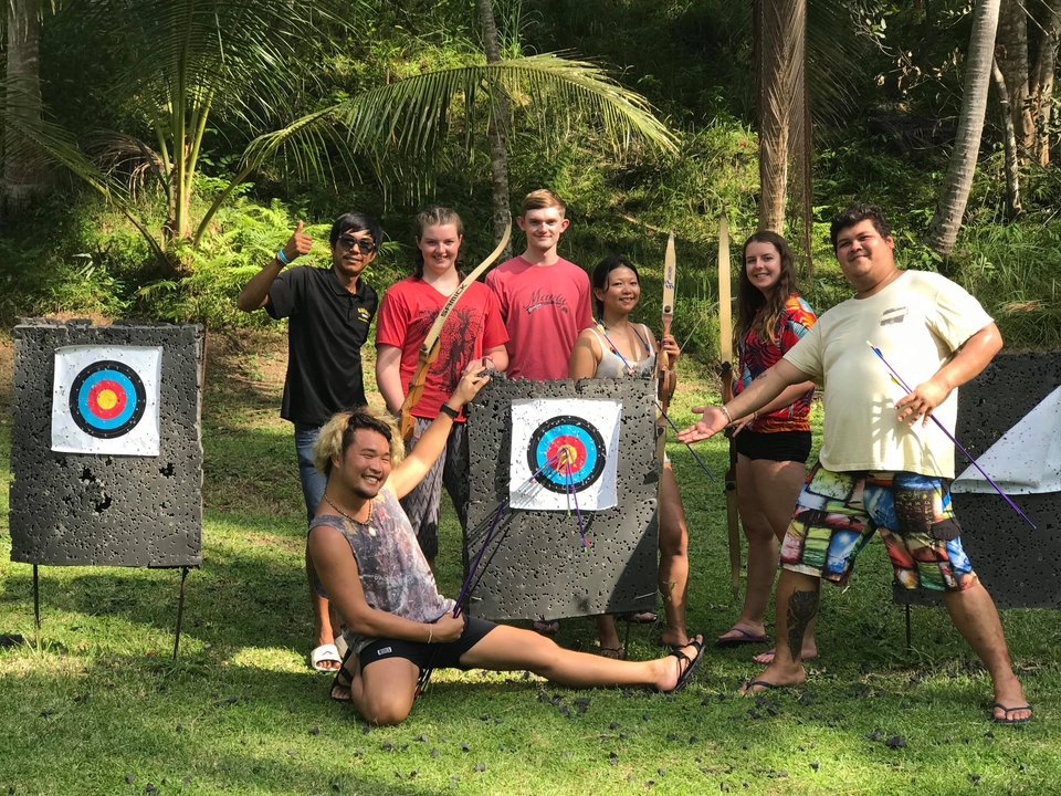 Group of people posing with archery targets.
