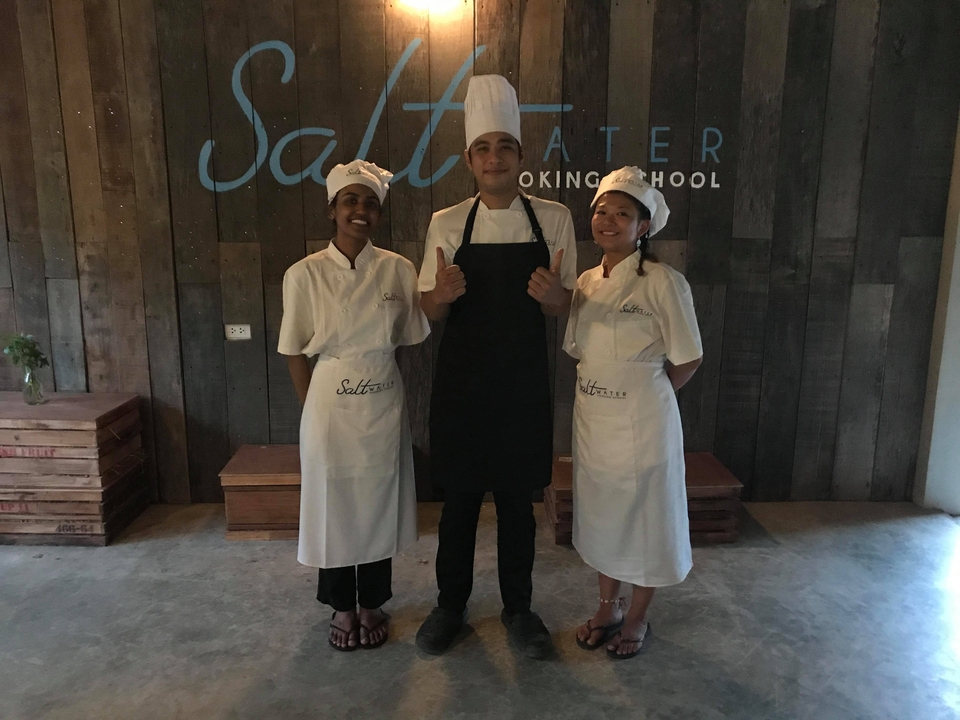 People in cooking school uniforms posing for a photo.