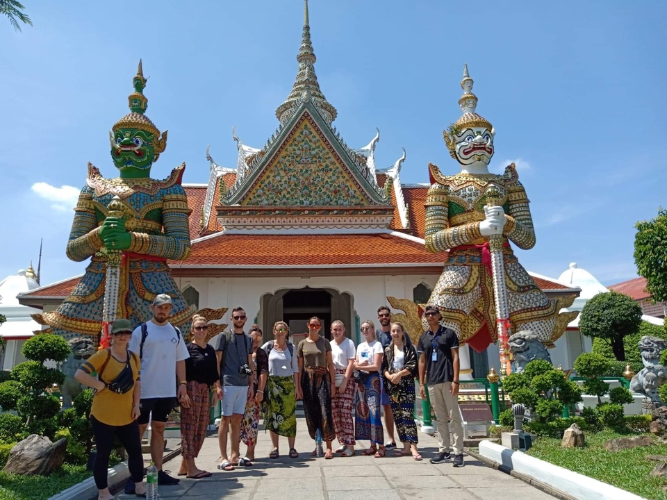 Group posing in front of a temple with guardian statues.
