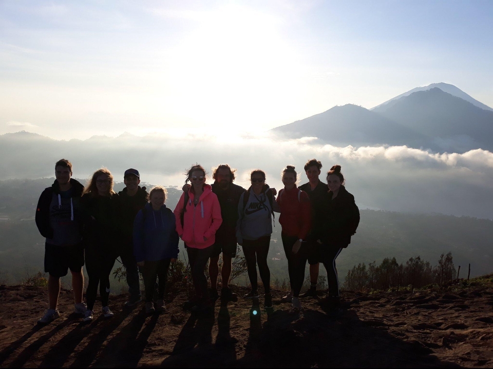 Group silhouette with a mountain backdrop.