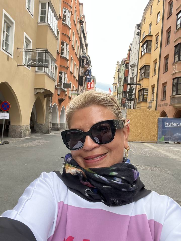 Woman wearing sunglasses in front of a cityscape.