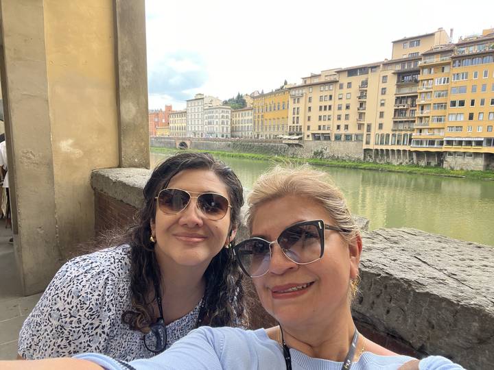 Upside-down image of people by a river with buildings.