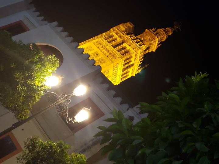 Tour illuminée et lampadaires la nuit.