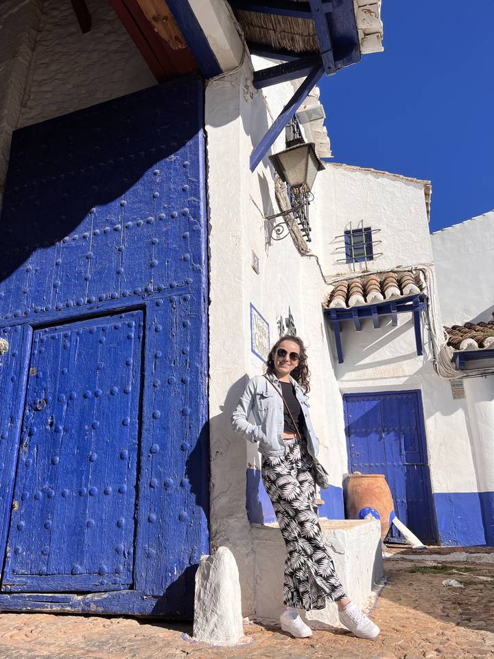 Person in front of bright blue and white building
