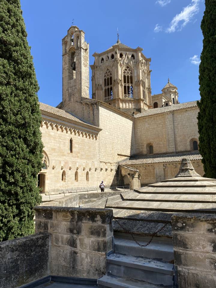 View of a historic stone building with intricate architecture and a clear blue sky.