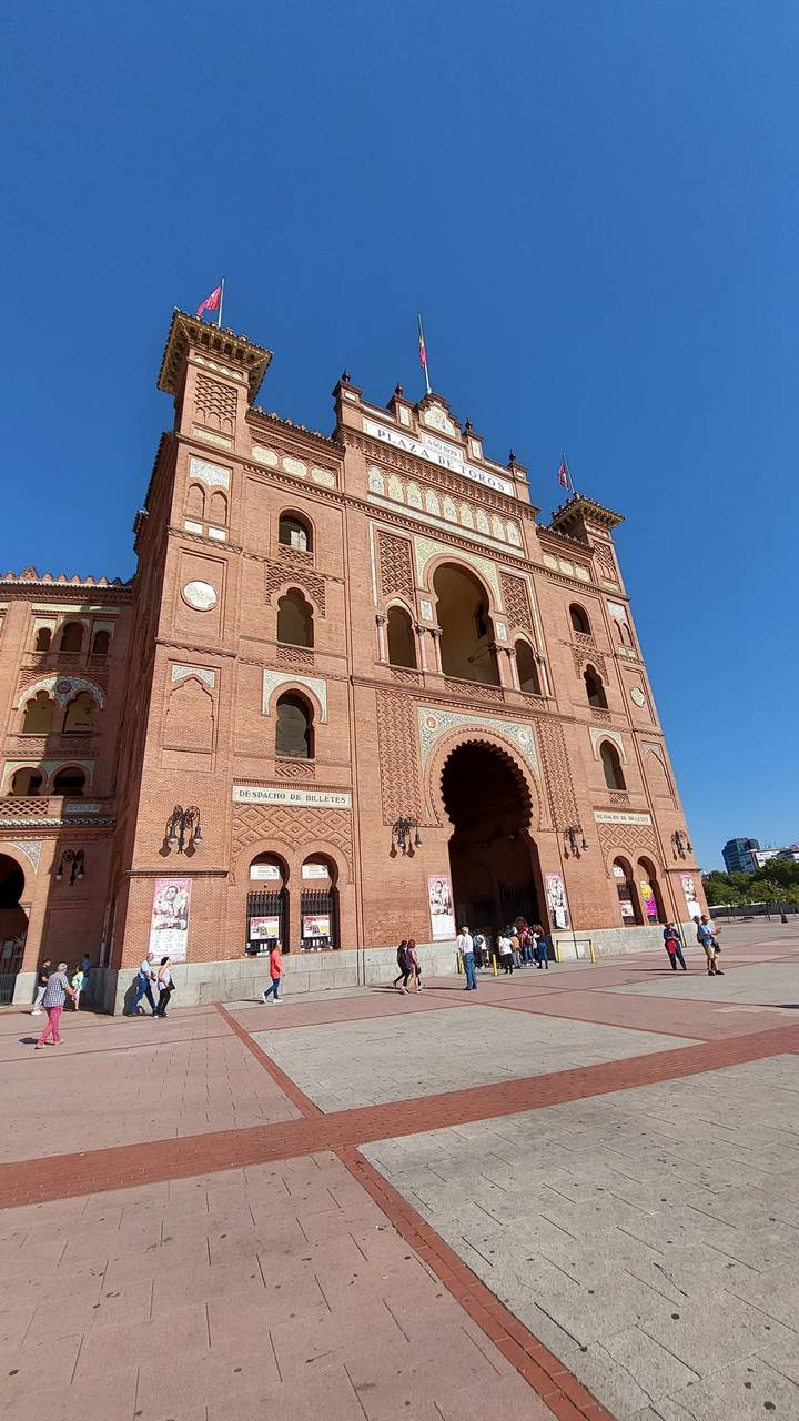 Large brick building with arches and flags.