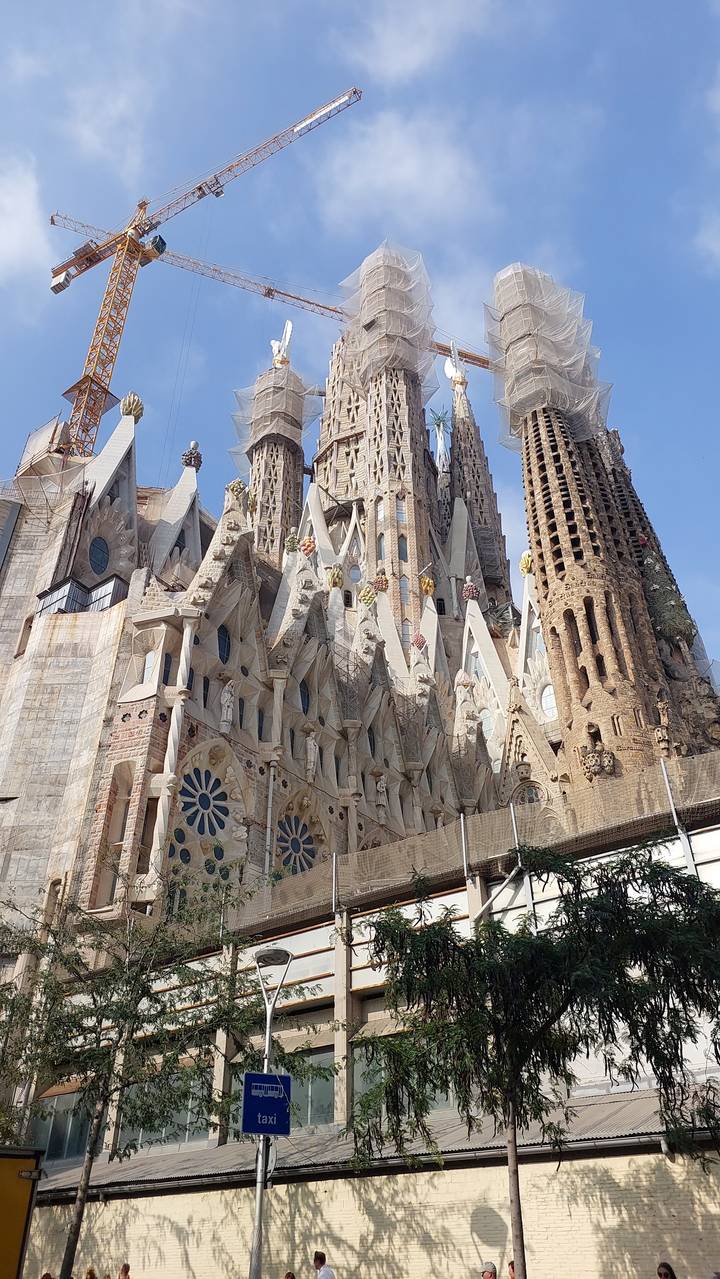Large cathedral with towers and cranes in the background.