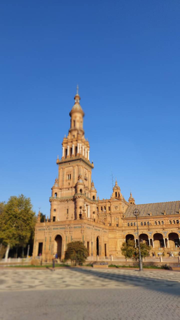 A historical building with a tall tower against a blue sky.