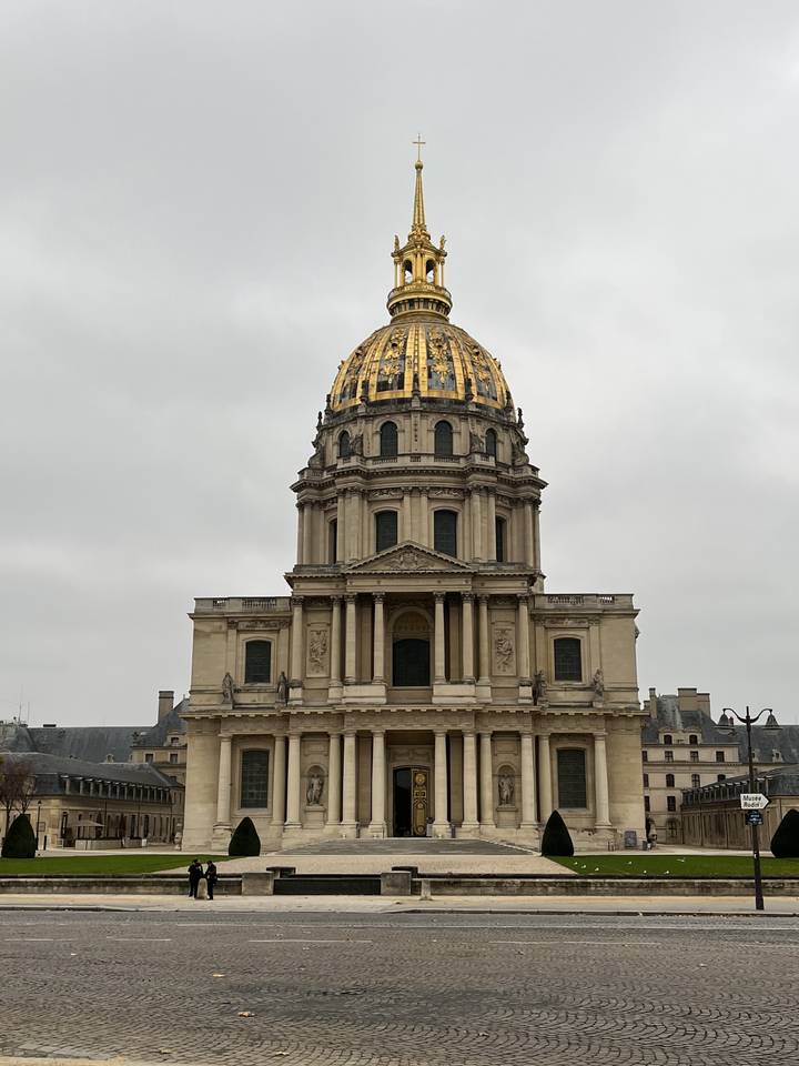 The text you provided is already mostly in French. Here's the translation with the English parts converted to French:

"Les Invalides à Paris, France avec un ciel nuageux en arrière-plan."

Note: "Les Invalides" remains the same as it's the proper name of the monument in French.