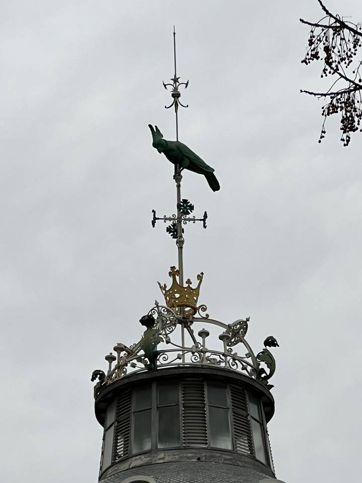 Gros plan d'une girouette sur une tour.