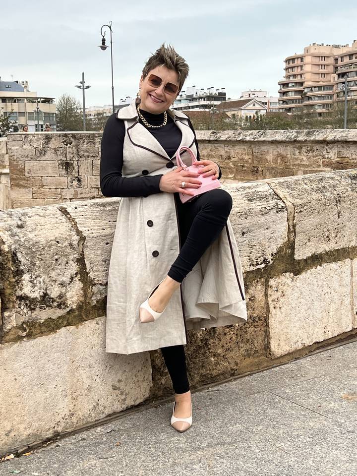 Une personne qui pose sur une structure en pierre.