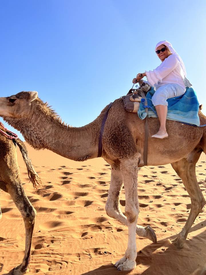 Personne montant un chameau dans le désert.