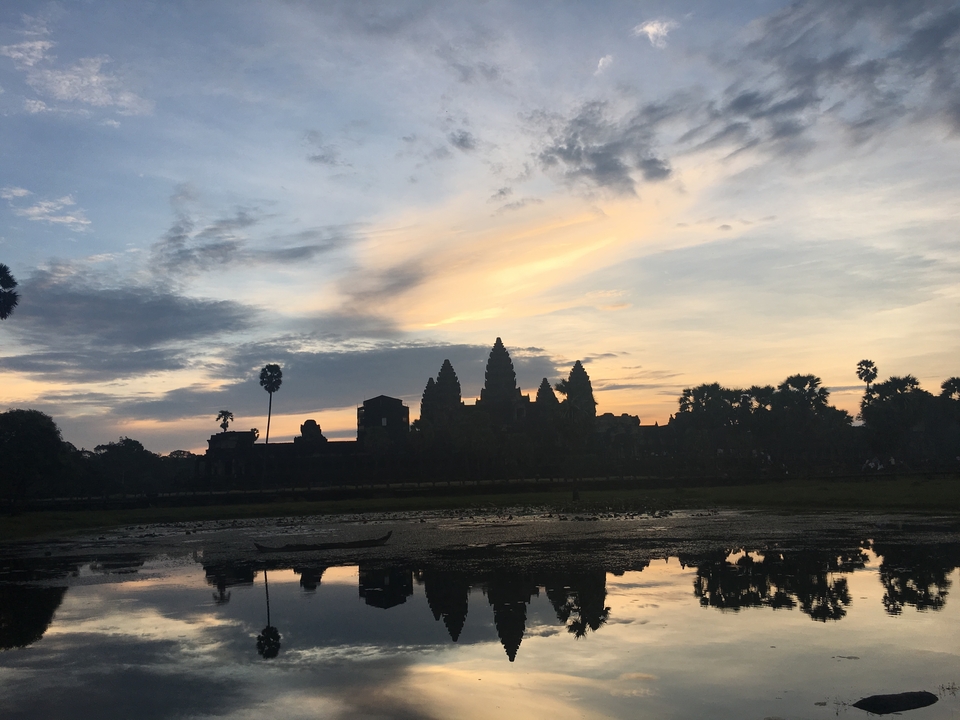 Silhouette d'Angkor Vat au lever du soleil avec reflets.