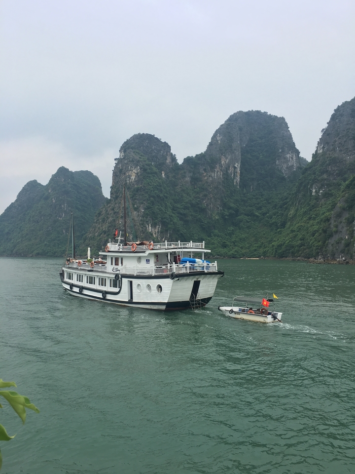 Bateau de croisière devant des paysages calcaires.