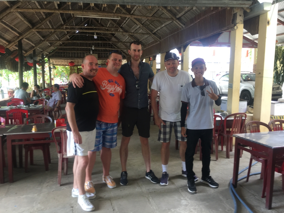 Groupe d'amis qui posent dans un restaurant en plein air.
