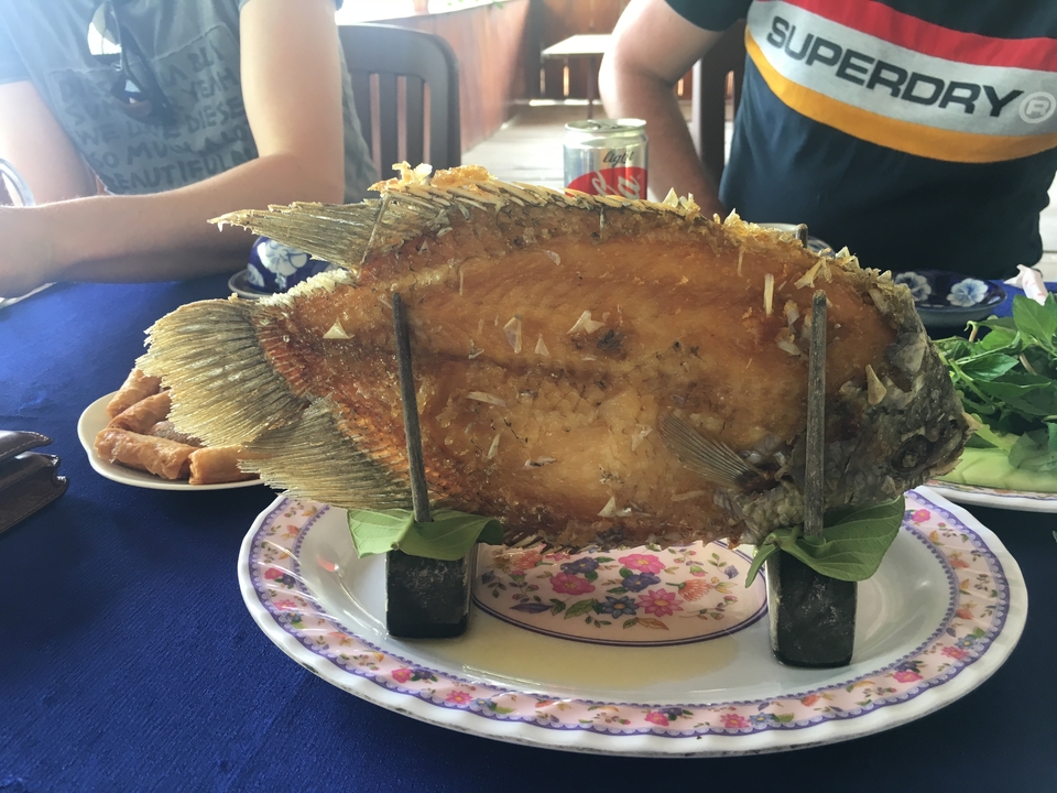 Plat de poisson frit servi dans une assiette décorée.