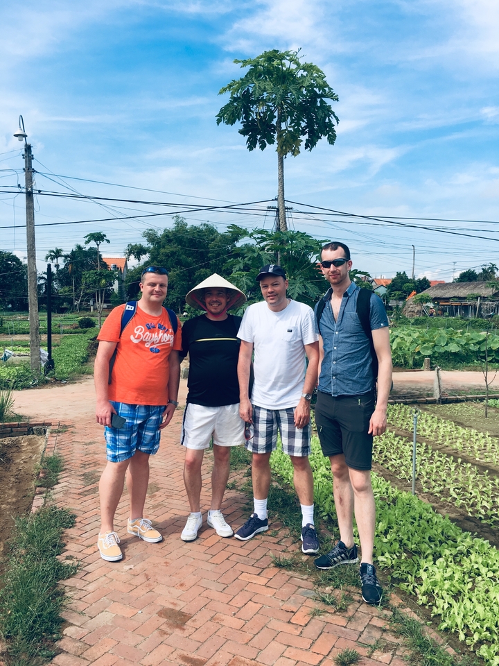 Groupe de touristes posant dans un jardin.