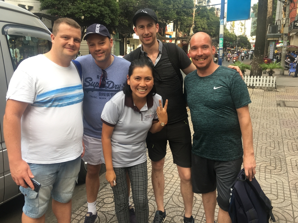 Groupe de touristes avec un guide local prenant la pose pour une photo.