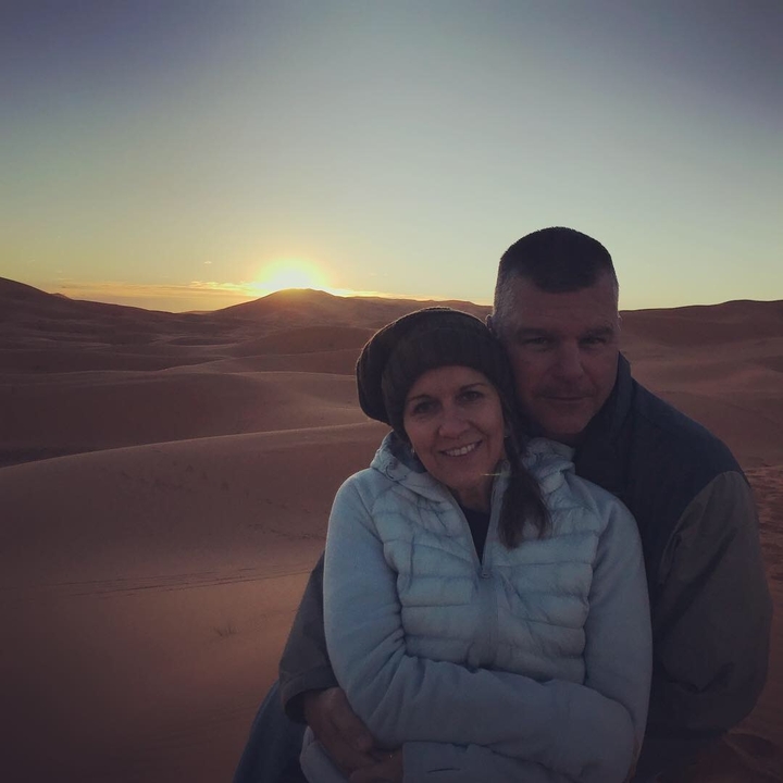 Couple in the desert with sunset in the background.
