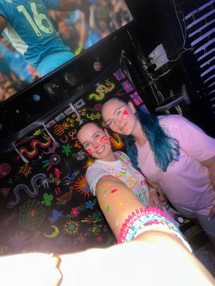 Two people with neon face paint at a party