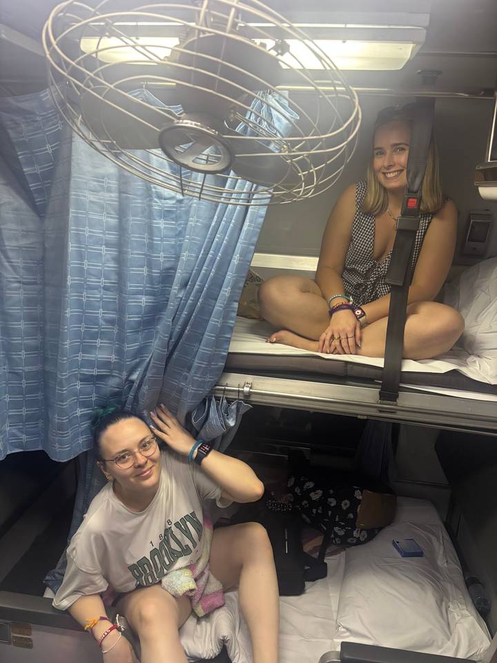 Two people sitting in a train compartment.