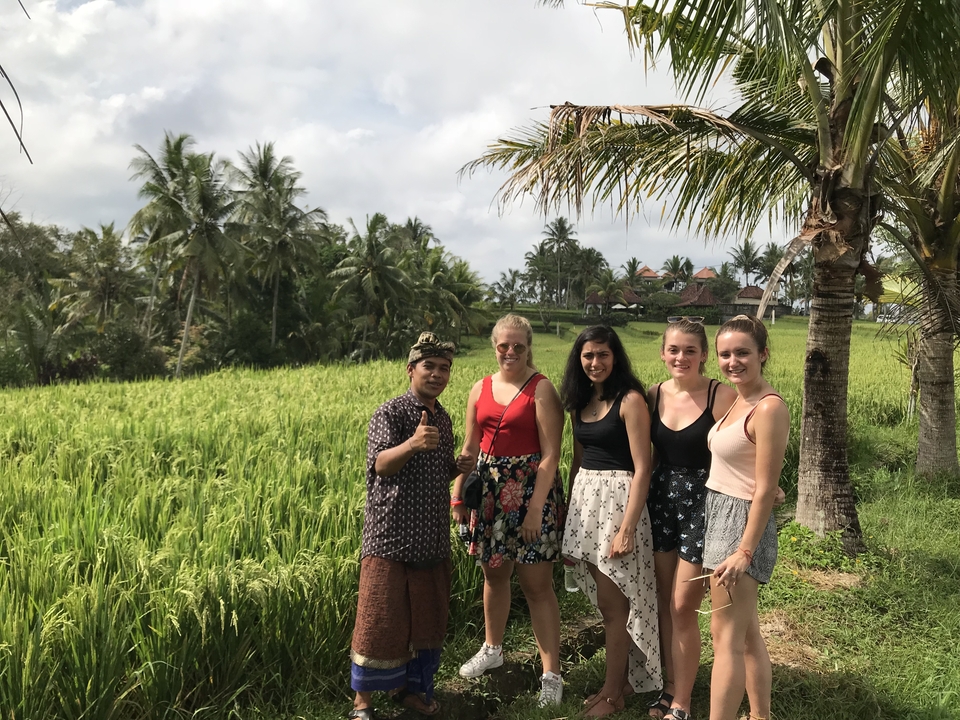 A group of people posing in rice fields.