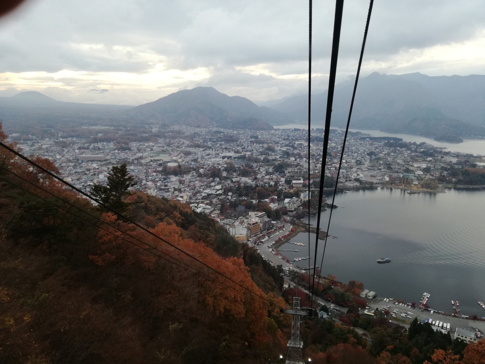 Elevated view of a town and mountains with a lake.
