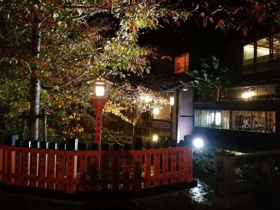 Traditional style lantern and fence at night with autumn colors.