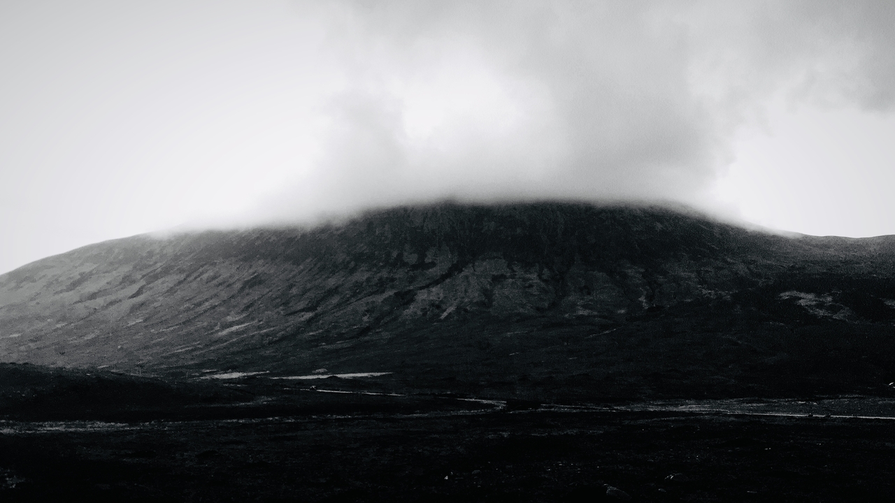 A mountain with clouds descending upon it.