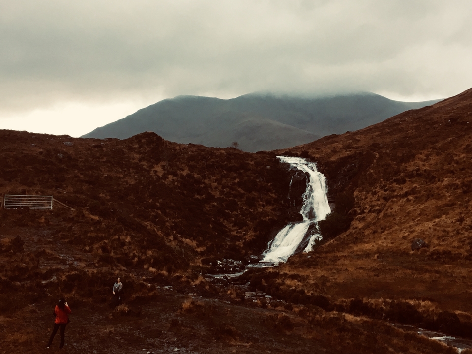 A scenic waterfall flowing down a rocky hillside.