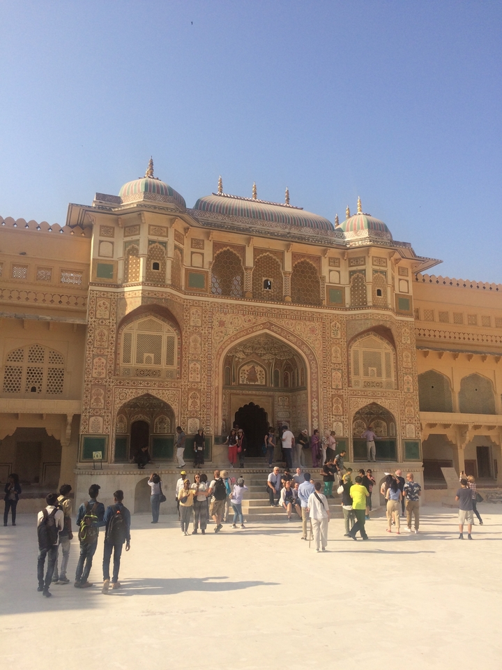 A group of people gathered at the intricately decorated Amber Fort.
