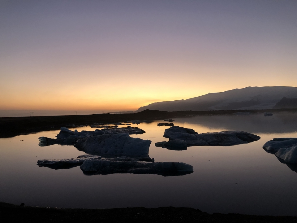 Icebergs in a lagoon at sunset.