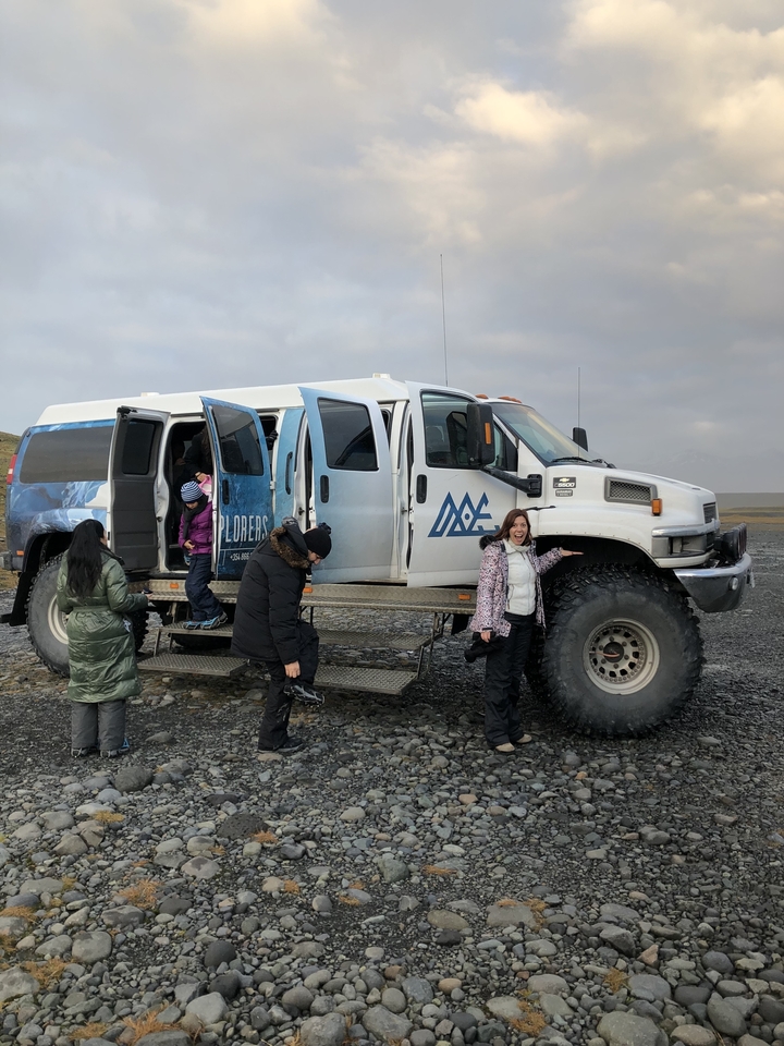 People standing next to a rugged tour vehicle.