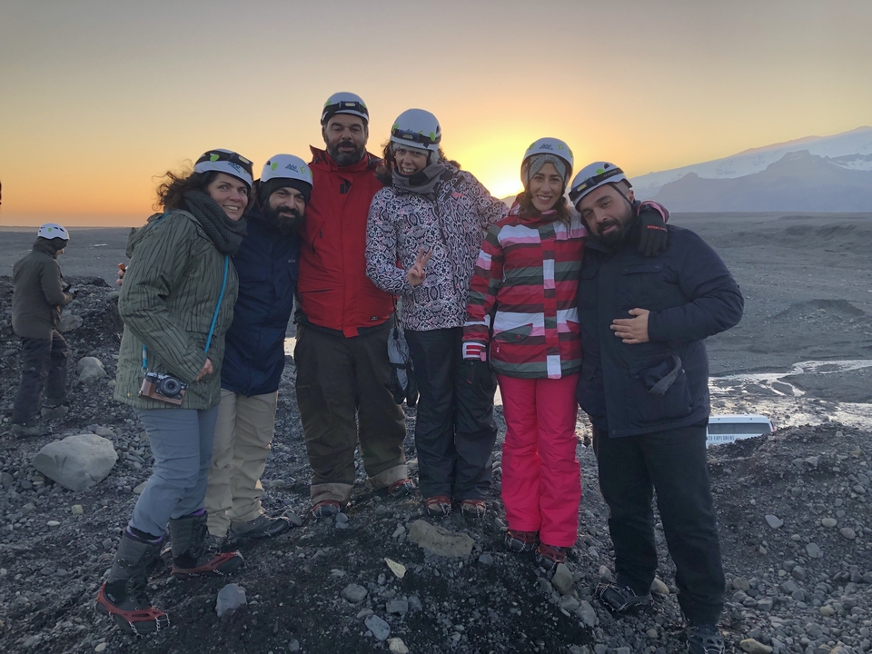 Group of people posing at sunset in winter gear.