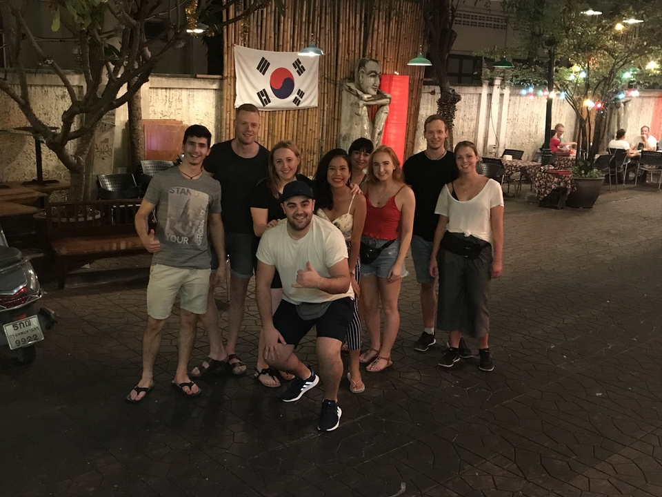 Group posing under a sign with Korean flag.