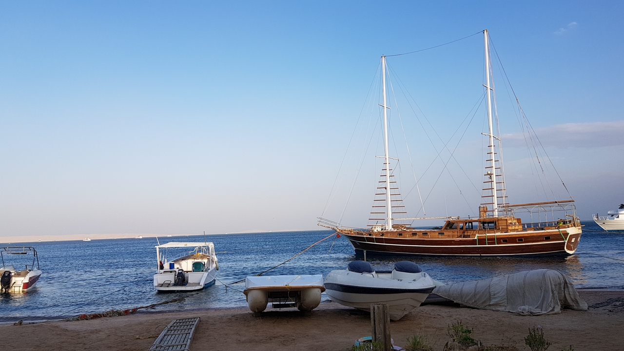 Wooden sailing boats anchored by the shore.
