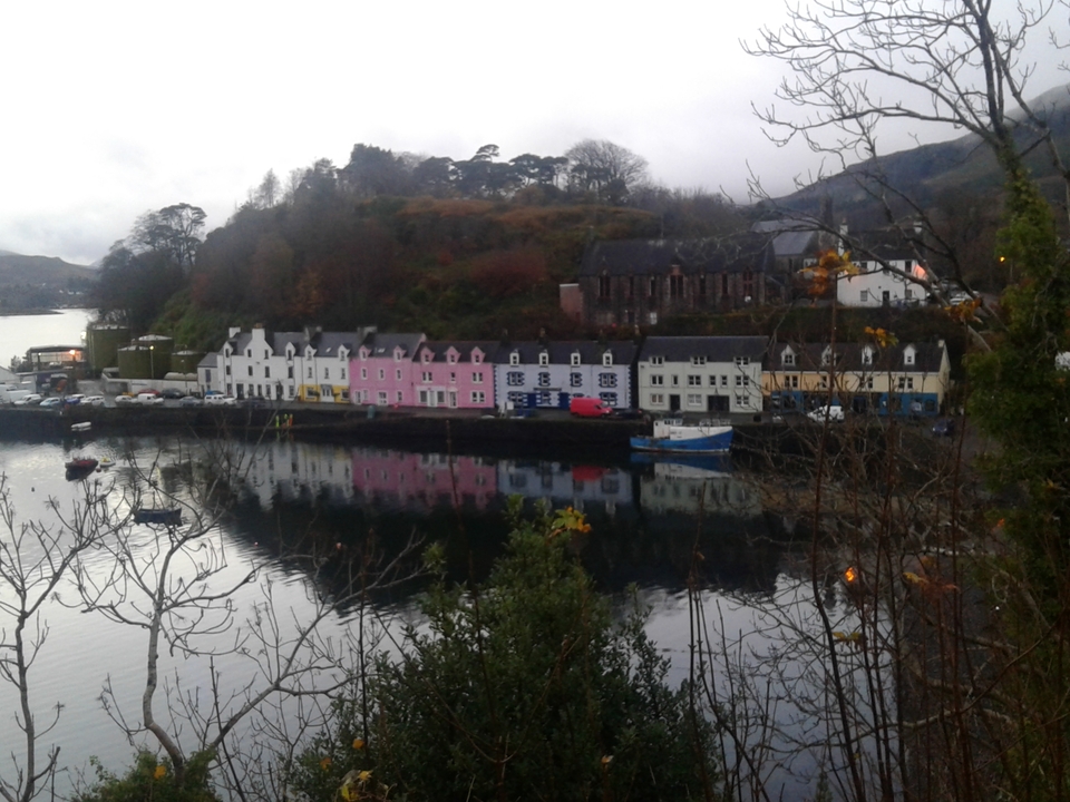 Des maisons colorées bordant un front de mer avec des bateaux dans l'eau.