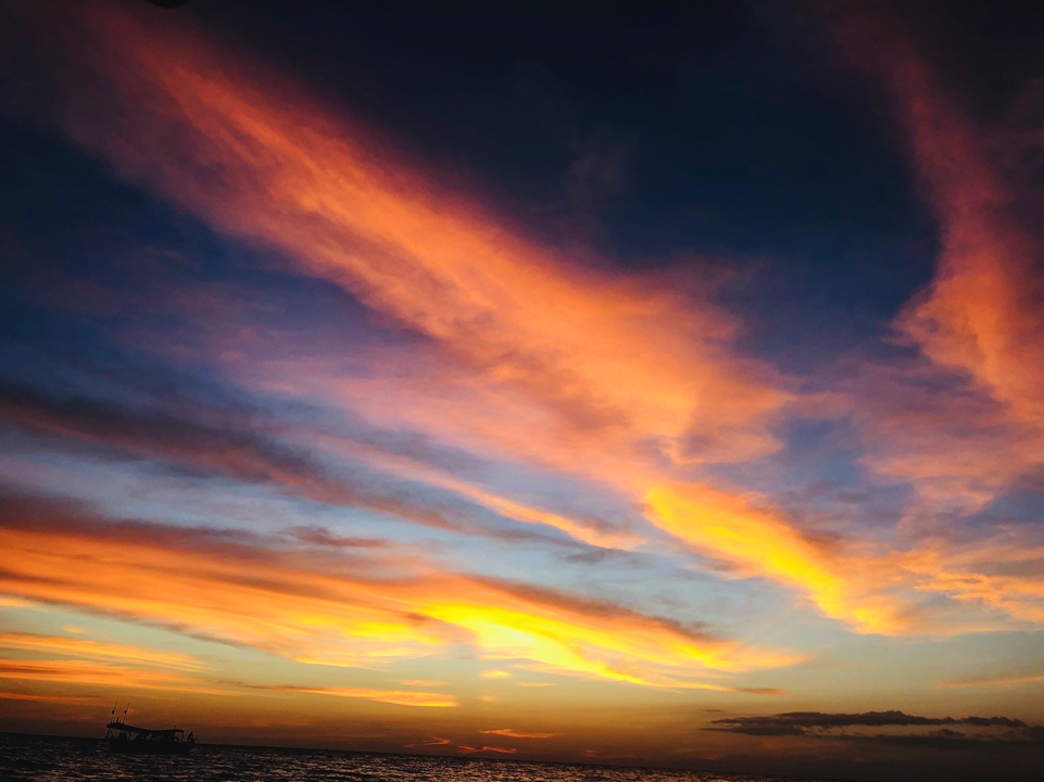 Vibrant sunset with streaks of orange and purple clouds.
