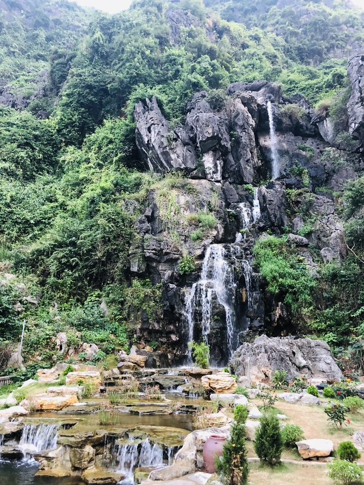 Water cascading over rocks in a lush, forested area.