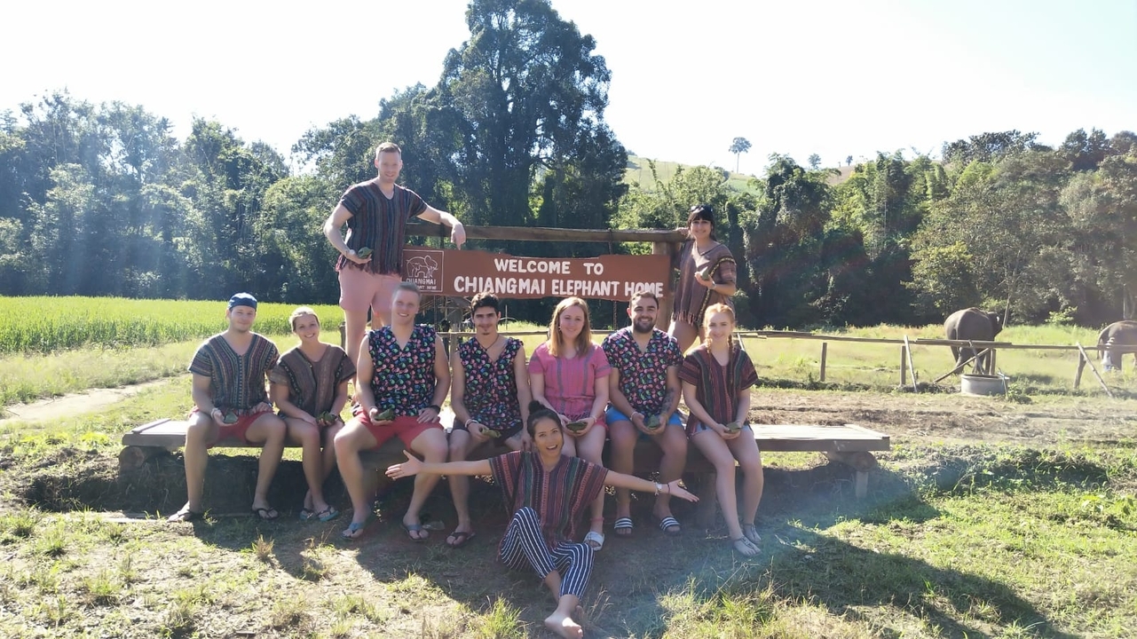 Group posing in front of a Chiang Mai Elephant Home sign.