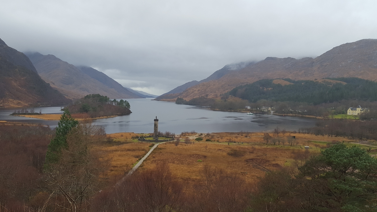 Scenic landscape with a monument by a loch.
