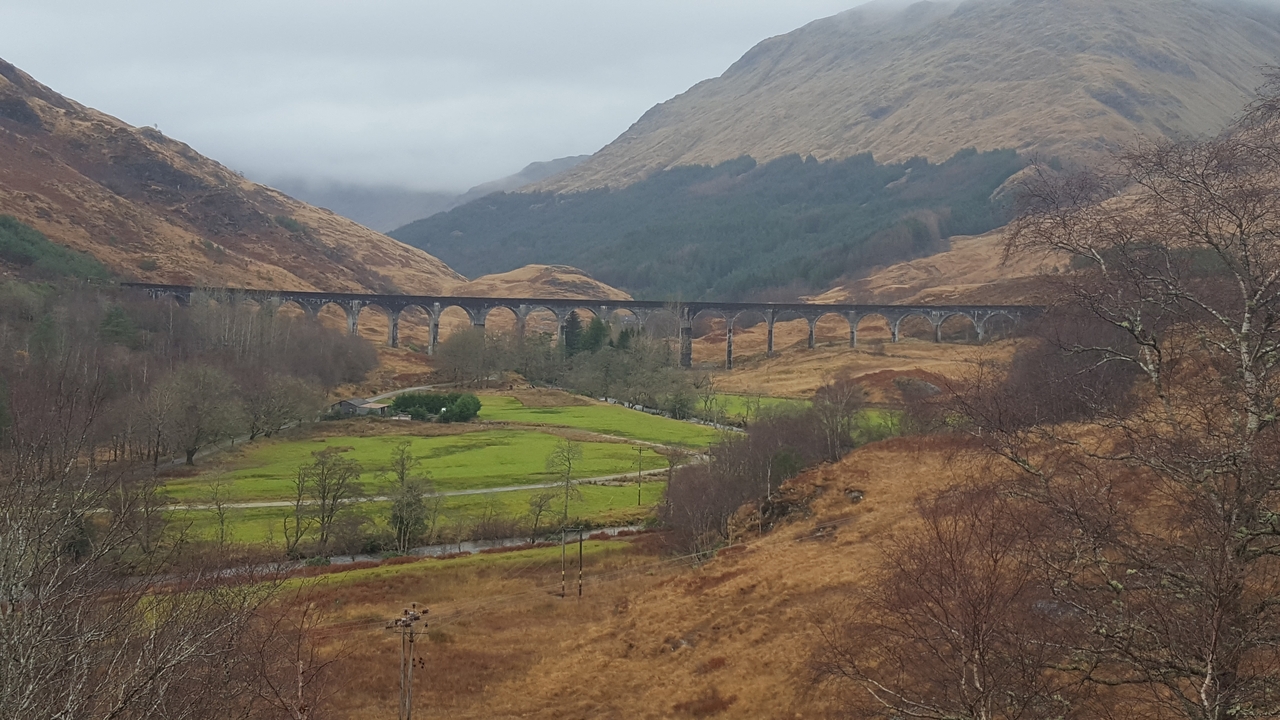 Lush valley with a viaduct stretching across.