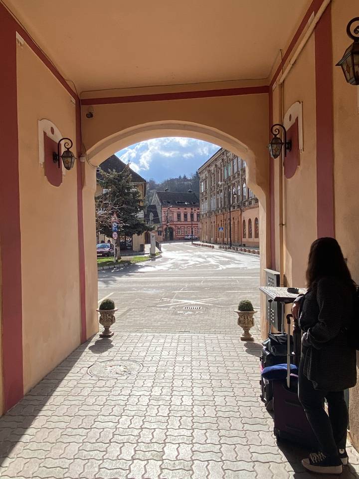 Archway leading to a view of a street with buildings.