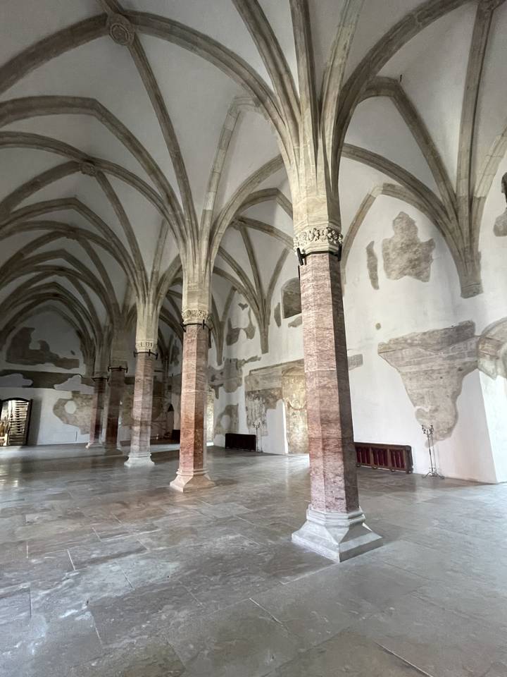 Interior of a historical building with pillars and arched ceiling.