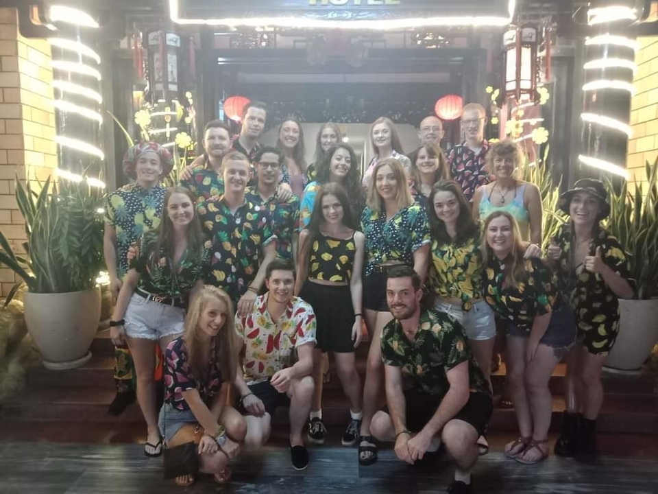 Large group of people posing at an entrance.